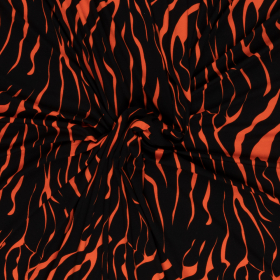 zwart oranje stretch tricot met grillig fantasie dessin bedrukt