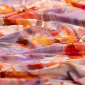 Lila stretch tricot stof met oranje, oud-roze, rood bladdessin