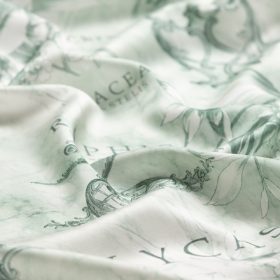 gebroken wit  viscose satijnstof met oud groen fantasie dessin Italiaans import